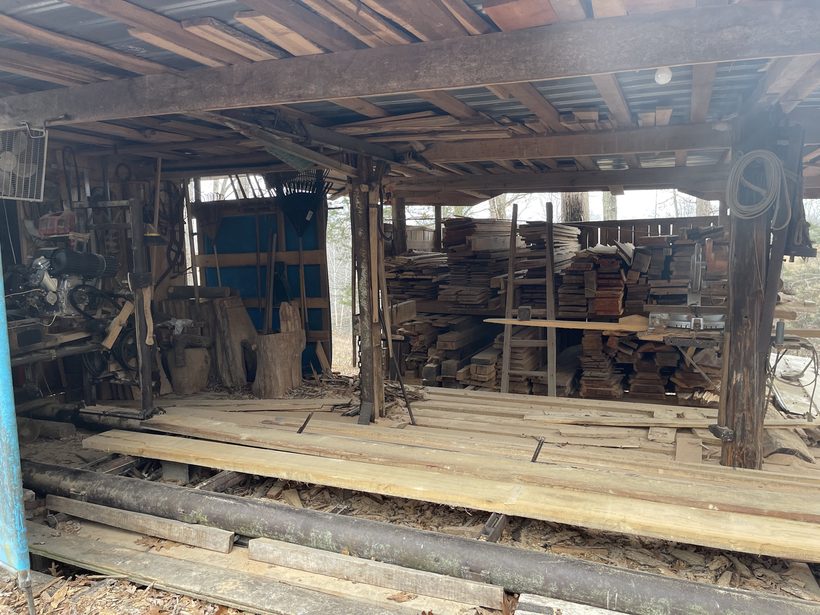 The open sided lumber shed at Counterwood with sawn boards stacked on racks and on the deck.