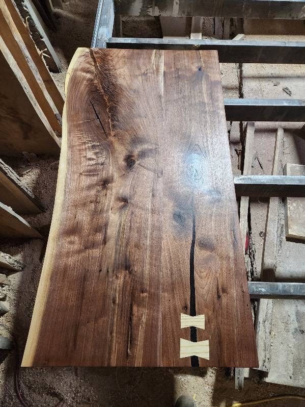 A walnut top with two pale butterfly keys inlaid across a dark check running down the middle.