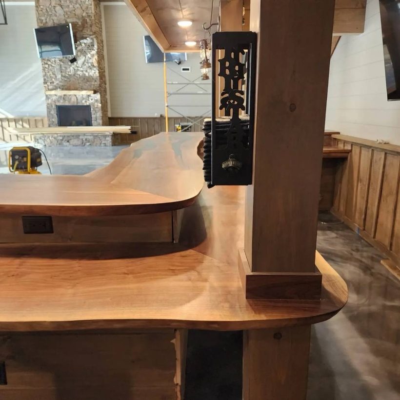 A finished hardwood bar top installed with a curved return around a timber post.